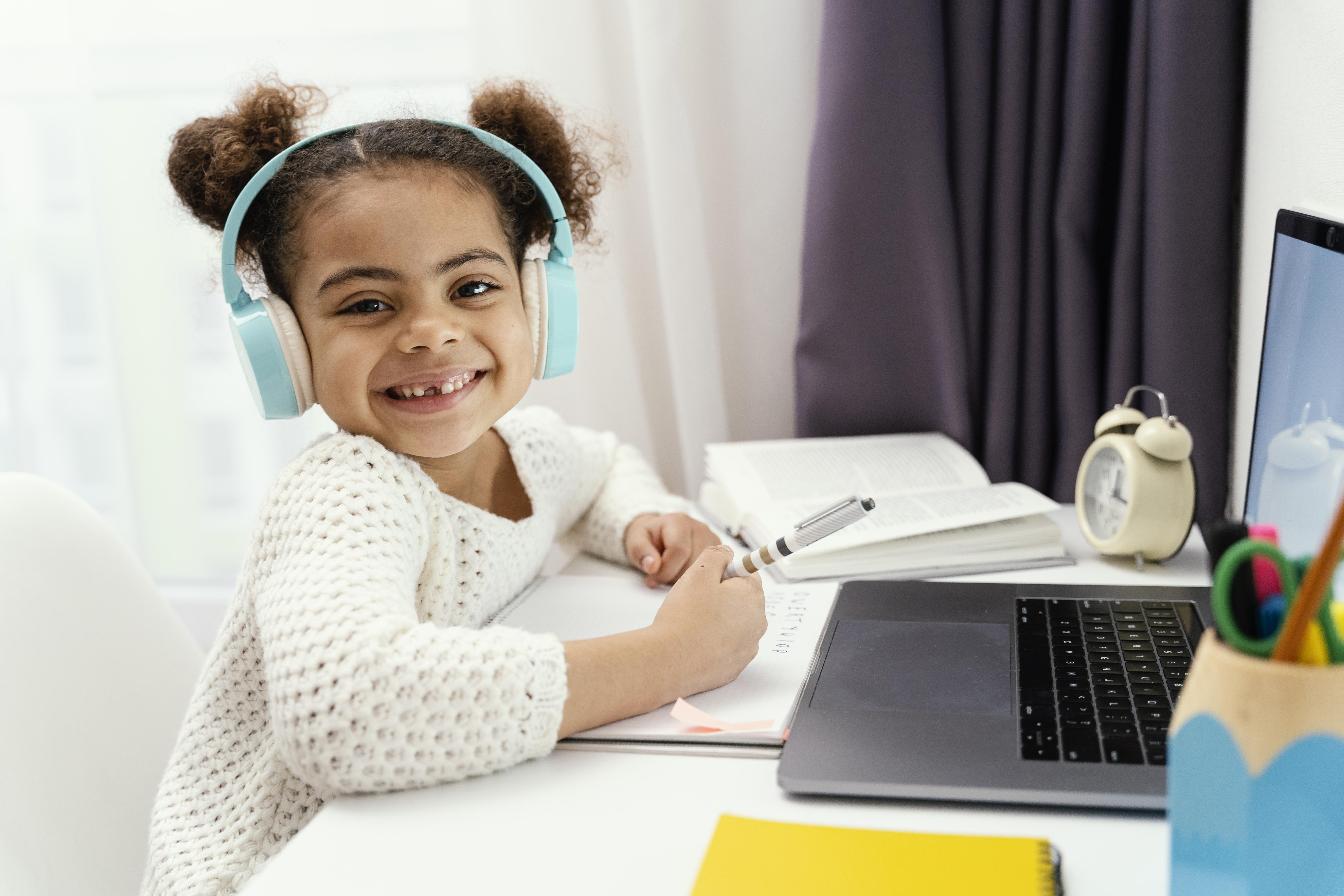 little-girl-home-during-online-school-with-laptop-headphones